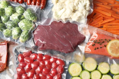 Photo of Many different food in vacuum packings as background, top view