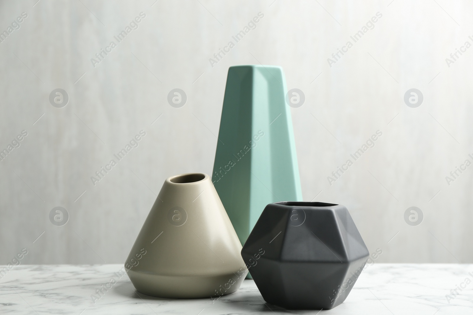 Photo of Stylish empty ceramic vases on white marble table