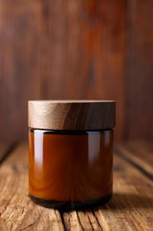 Photo of Jarluxury cream on wooden table, closeup