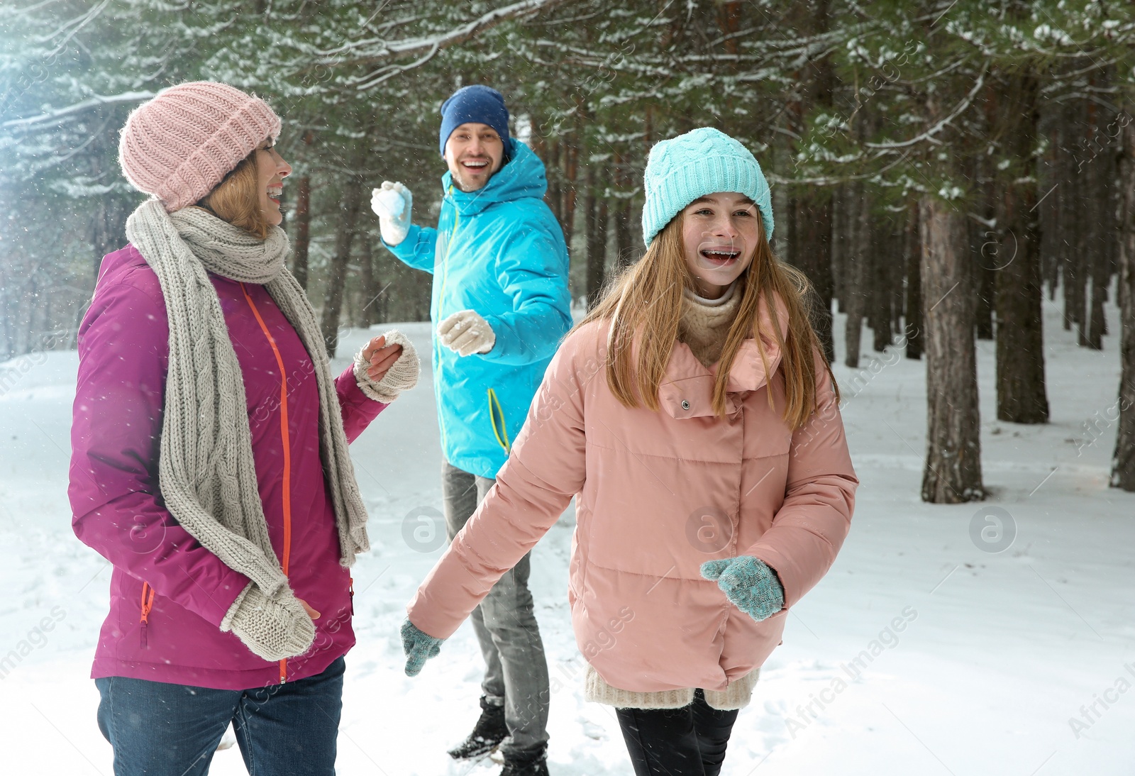 Photo of Happy family playing snowballs in winter forest