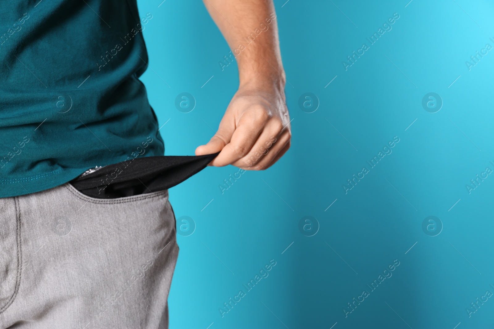 Photo of Man showing empty pocket on color background, closeup. Space for text