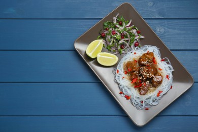 Photo of Pieces of soy sauce chicken with noodle, salad and lime on blue wooden table, top view. Space for text