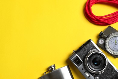 Set of traveler's equipment on yellow background, flat lay. Space for text