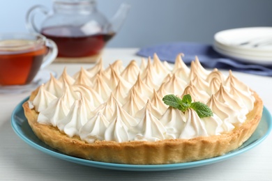 Delicious lemon meringue pie decorated with mint on white table