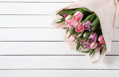 Bouquet of beautiful tulips on white wooden table, closeup. Space for text