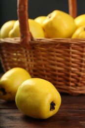 Basket with delicious ripe quinces on wooden table, closeup