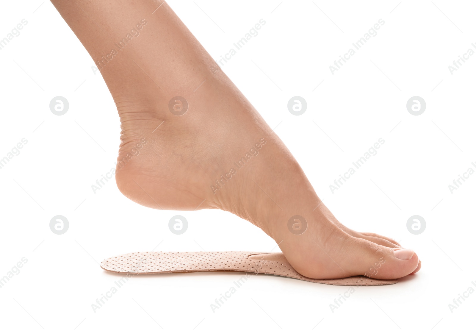 Photo of Woman fitting orthopedic insole on white background, closeup. Foot care