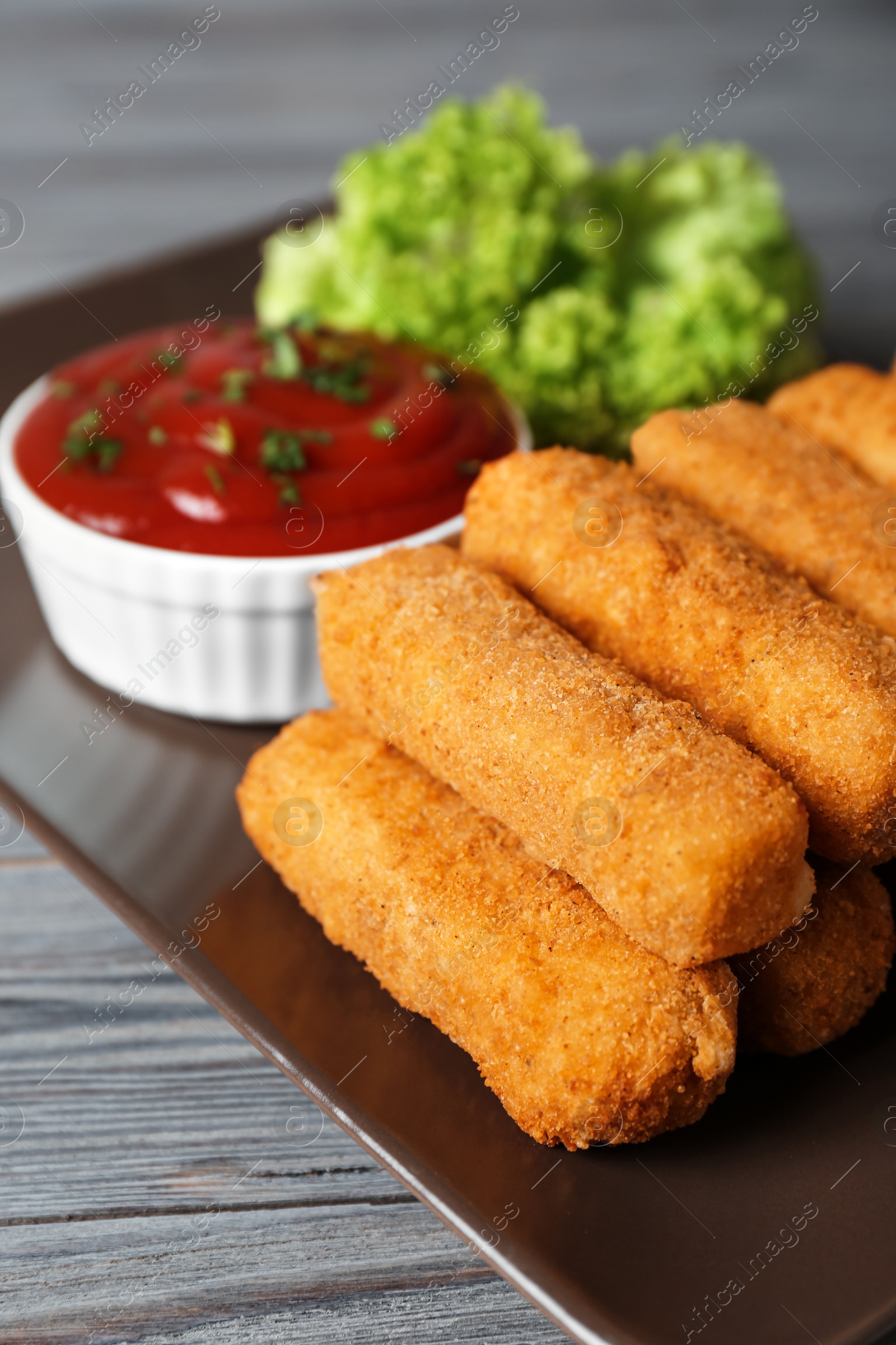 Photo of Plate of cheese sticks with sauce on table, closeup