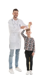 Photo of Doctor measuring little boy's height on white background