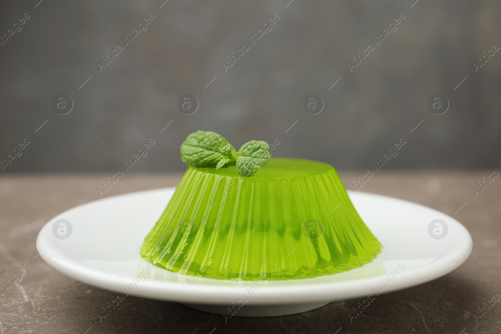 Photo of Plate with tasty fruit jelly and mint on beige table, space for text