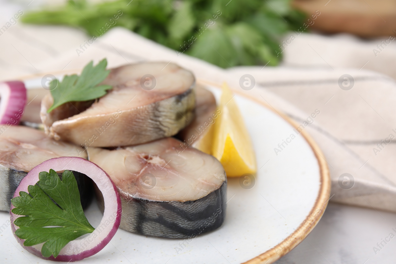 Photo of Slices of tasty salted mackerel with lemon and onion on table, closeup