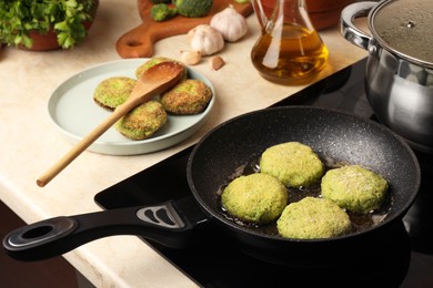 Photo of Cooking vegan cutlets in frying pan on stove