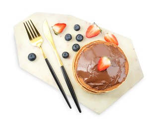 Photo of Delicious pancakes with chocolate paste, berries and cutlery isolated on white, top view