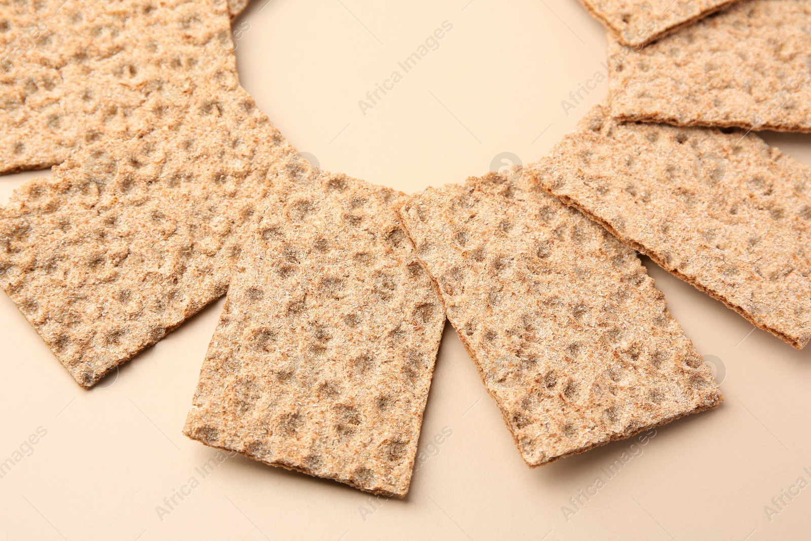 Photo of Many fresh crunchy crispbreads on beige background