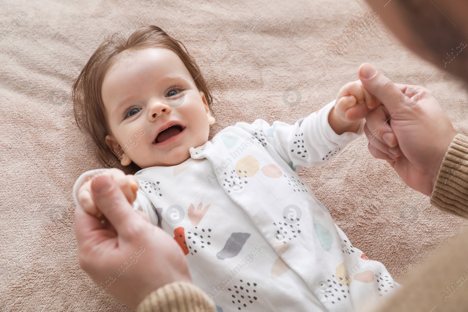 Photo of Father playing with his daughter on blanket, closeup