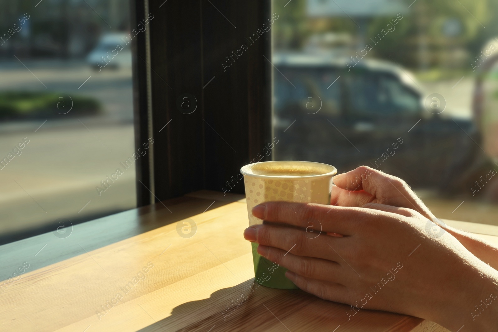 Photo of Woman with cup of fresh aromatic coffee at table in cafe