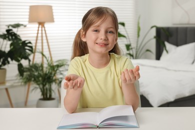 Cute little girl having online lesson indoors, view from web camera