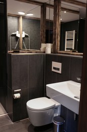 Photo of Stylish bathroom with toilet bowl in luxury hotel. Interior design