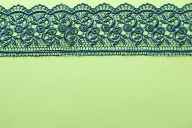 Beautiful lace on green background, top view. Space for text