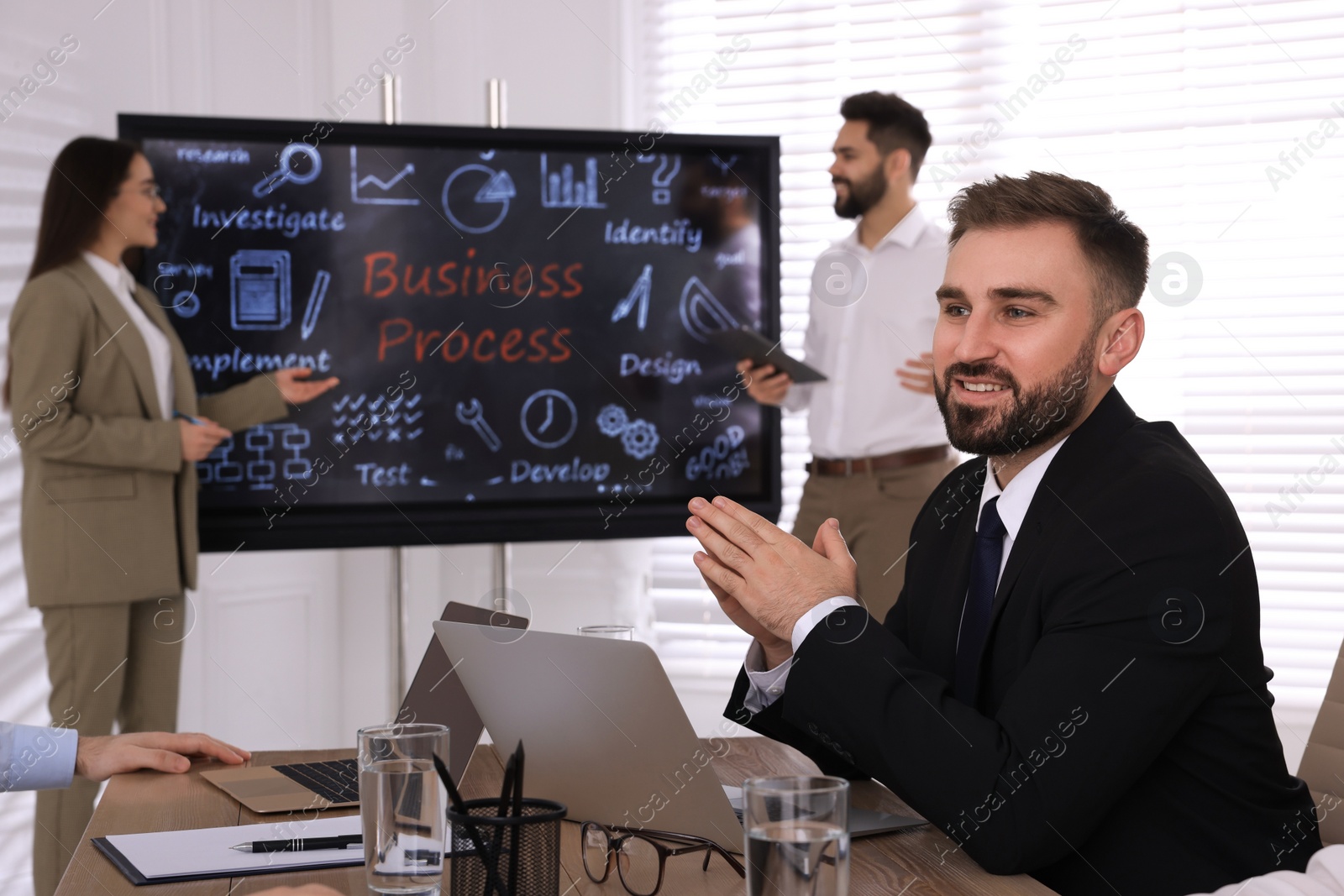 Photo of Business training. People in meeting room with interactive board