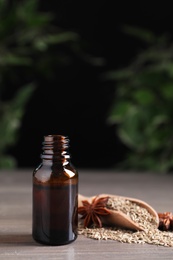 Photo of Anise essential oil and spice on table