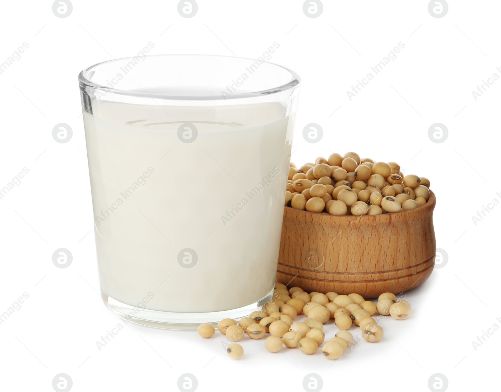 Photo of Glass of fresh soy milk and bowl with beans on white background