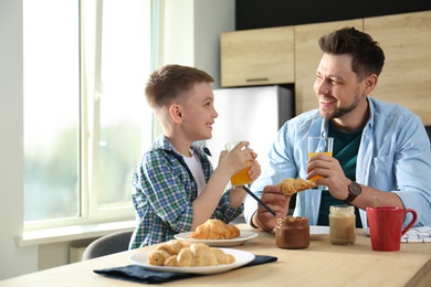 Photo of Dad and son having breakfast together in kitchen