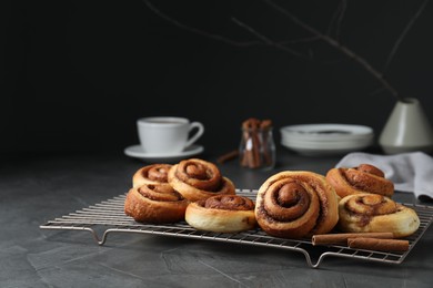 Photo of Tasty cinnamon rolls on black table, space for text