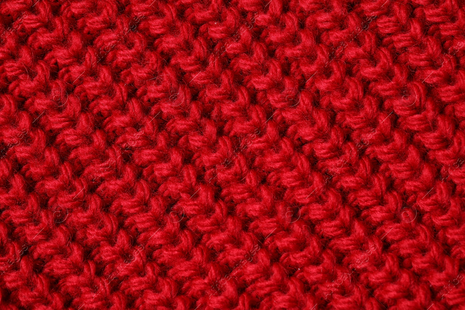 Photo of Texture of soft red knitted fabric as background, top view