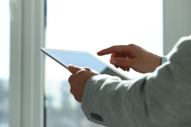 Photo of Closeup view of man using new tablet indoors