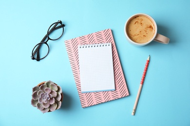 Photo of Flat lay composition with notebooks, coffee and plant on color background