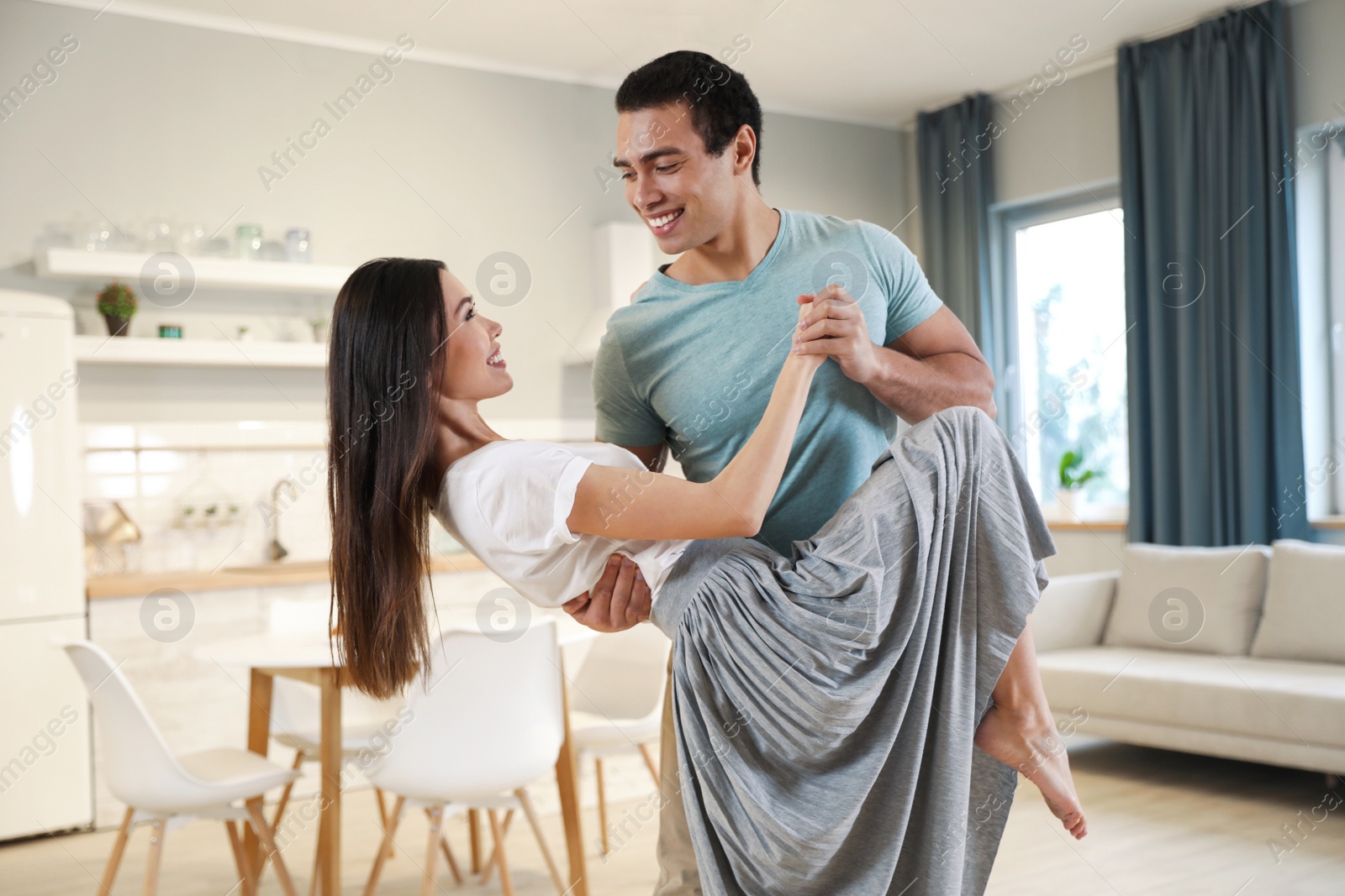 Photo of Lovely young interracial couple dancing at home