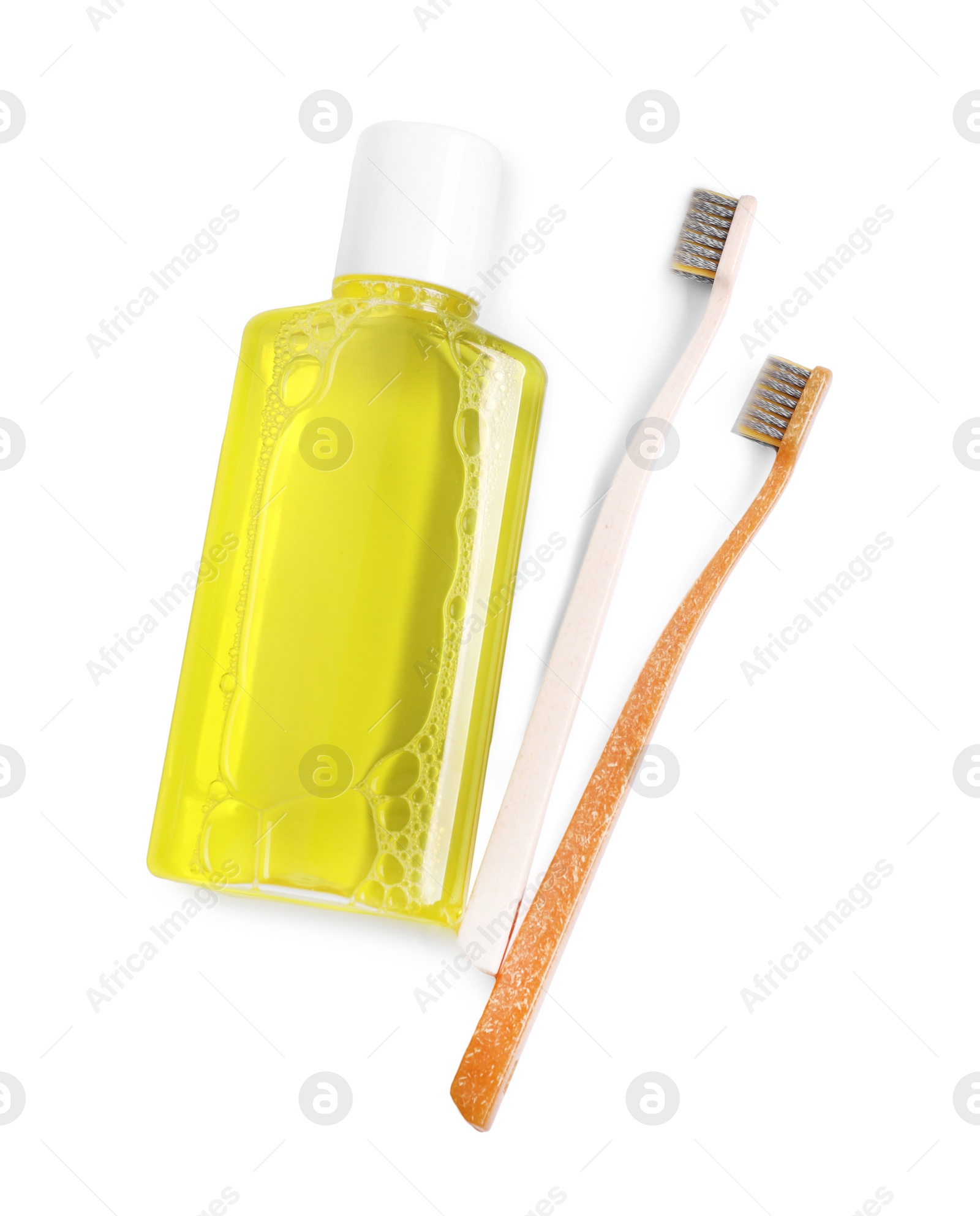 Photo of Fresh mouthwash in bottle and toothbrushes isolated on white, top view