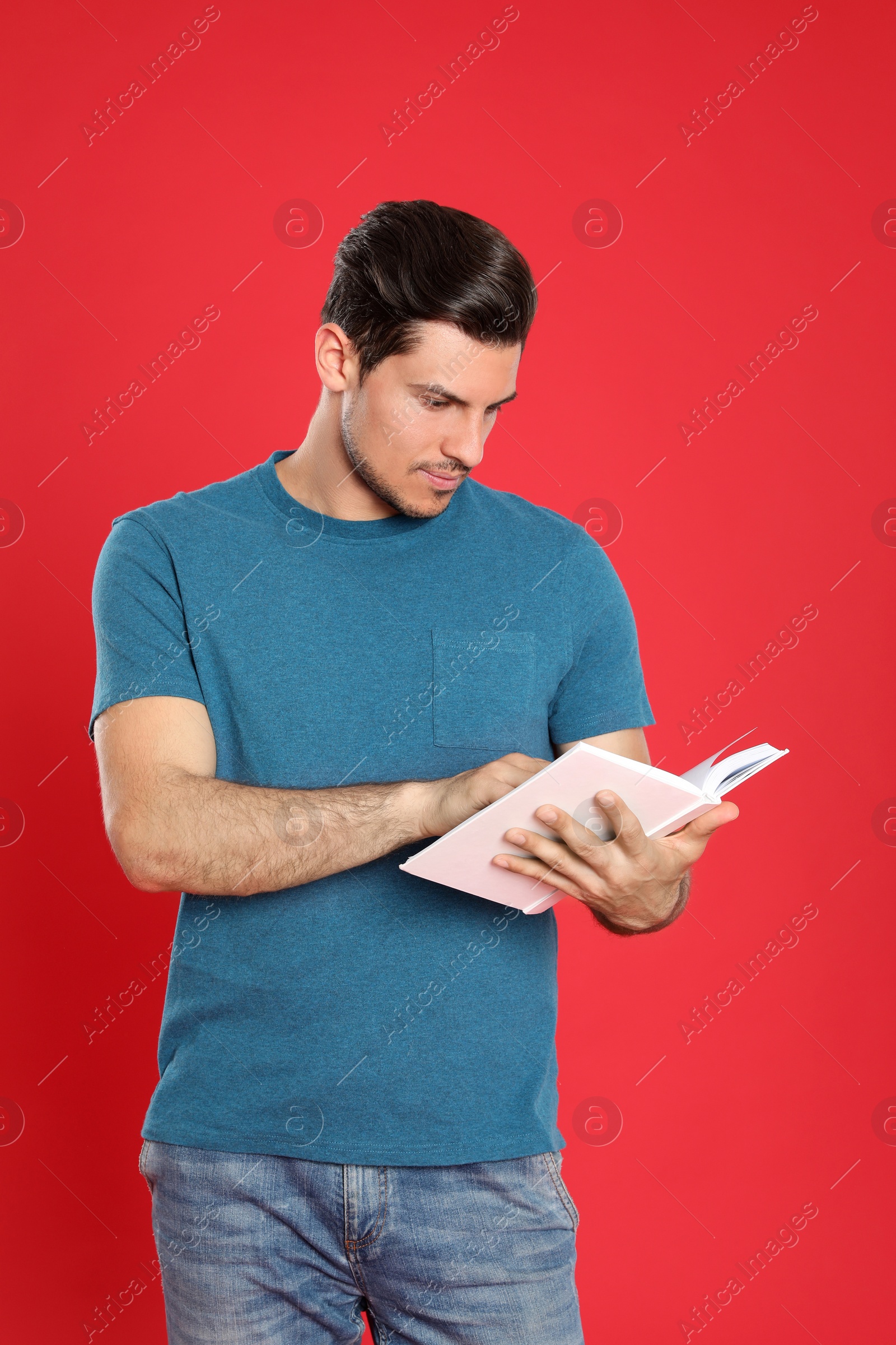 Photo of Handsome man reading book on color background