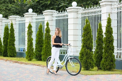 Beautiful woman in casual outfit with bicycle on city street