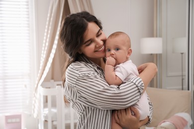 Happy young mother with her cute baby at home