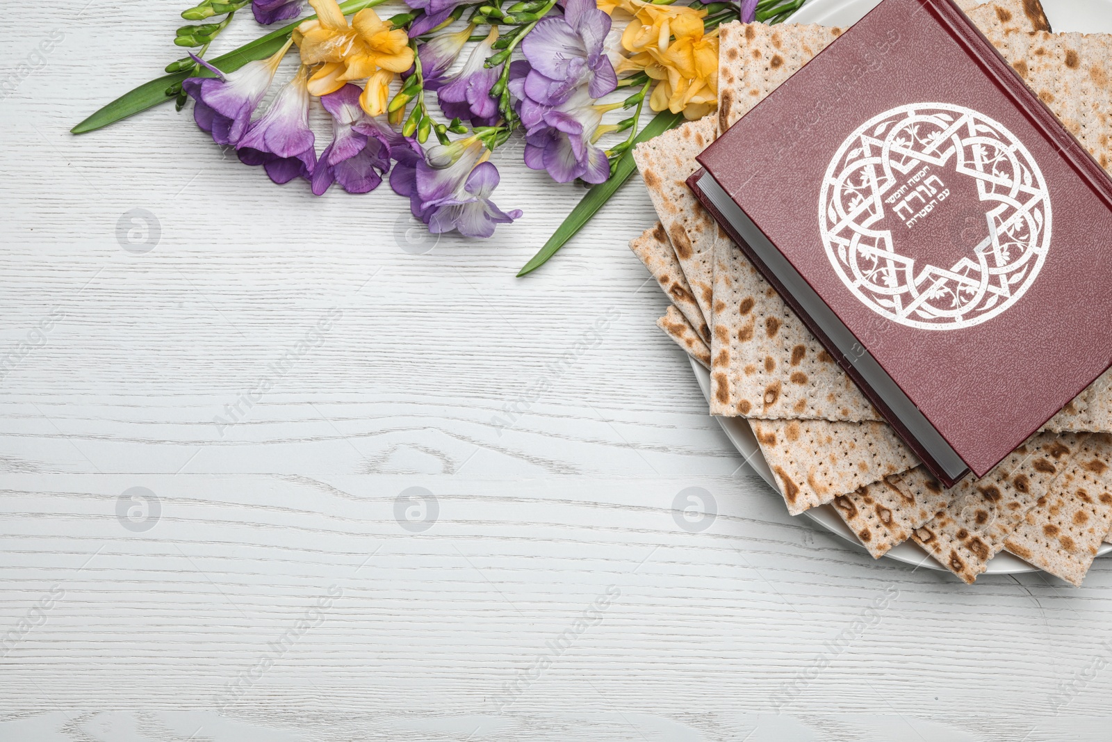 Photo of Flat lay composition with matzo and Torah on wooden background, space for text. Passover (Pesach) Seder