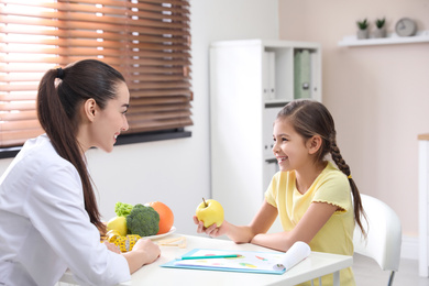 Little girl visiting professional nutritionist in office