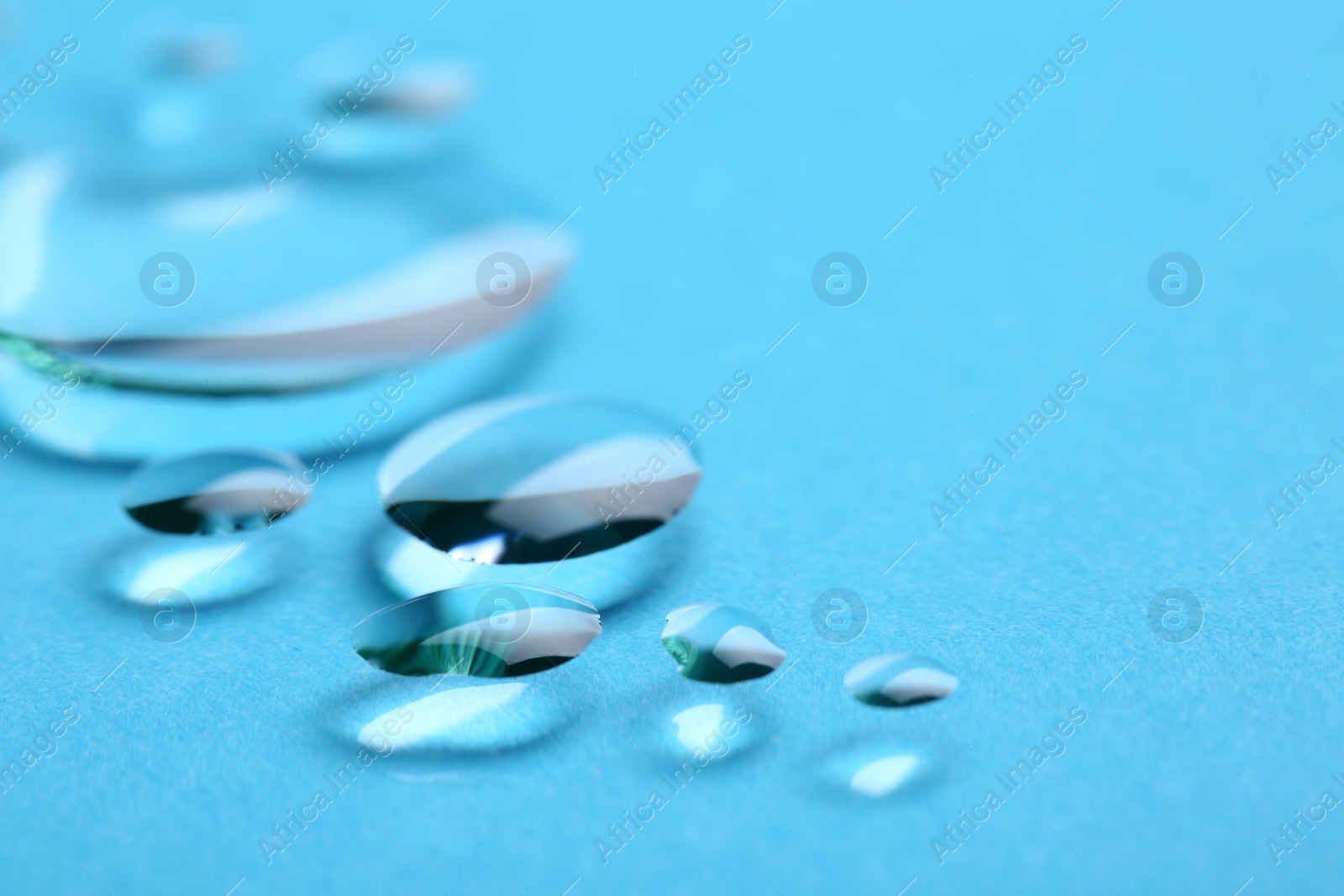 Photo of Pure water drops on color background, closeup. Space for text