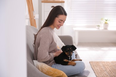 Photo of Woman with cute puppy indoors. Lovely pet