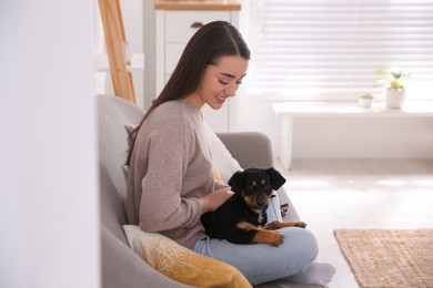 Woman with cute puppy indoors. Lovely pet