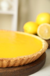 Photo of Delicious homemade lemon pie on white wooden table, closeup
