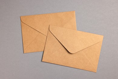 Envelopes made of parchment paper on grey background, flat lay
