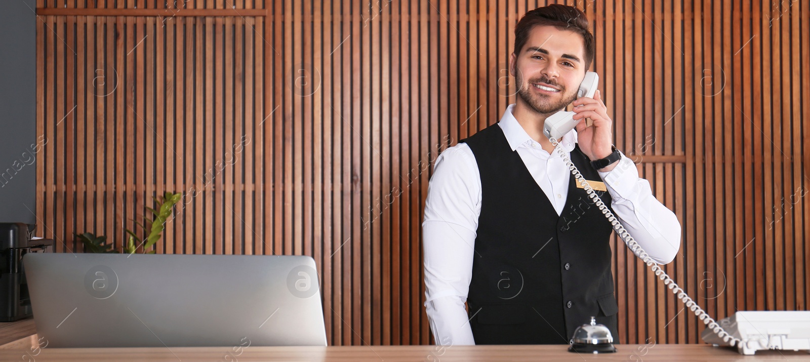 Image of Receptionist talking on phone at desk in lobby. Banner design