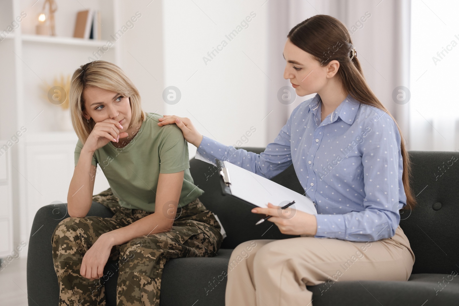 Photo of Psychotherapist working with military woman on sofa in office