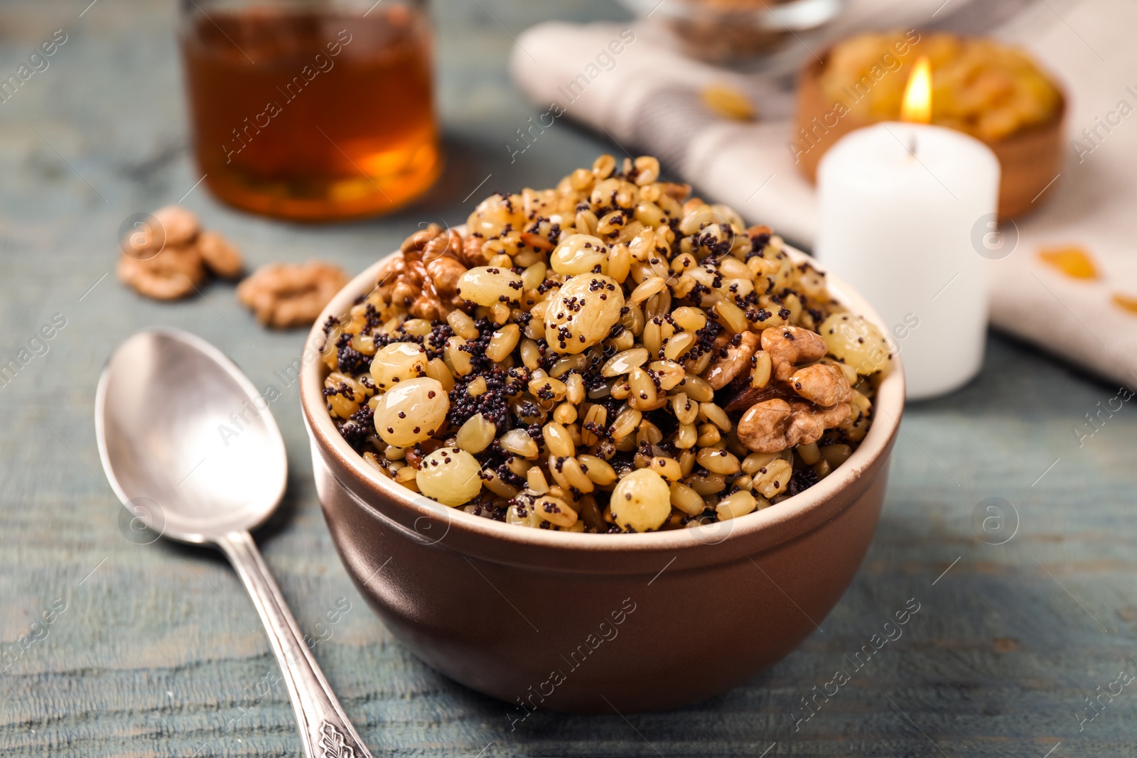 Photo of Traditional Christmas slavic dish kutia served on light blue wooden table, closeup