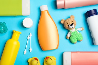 Flat lay composition with baby cosmetic products on light blue background