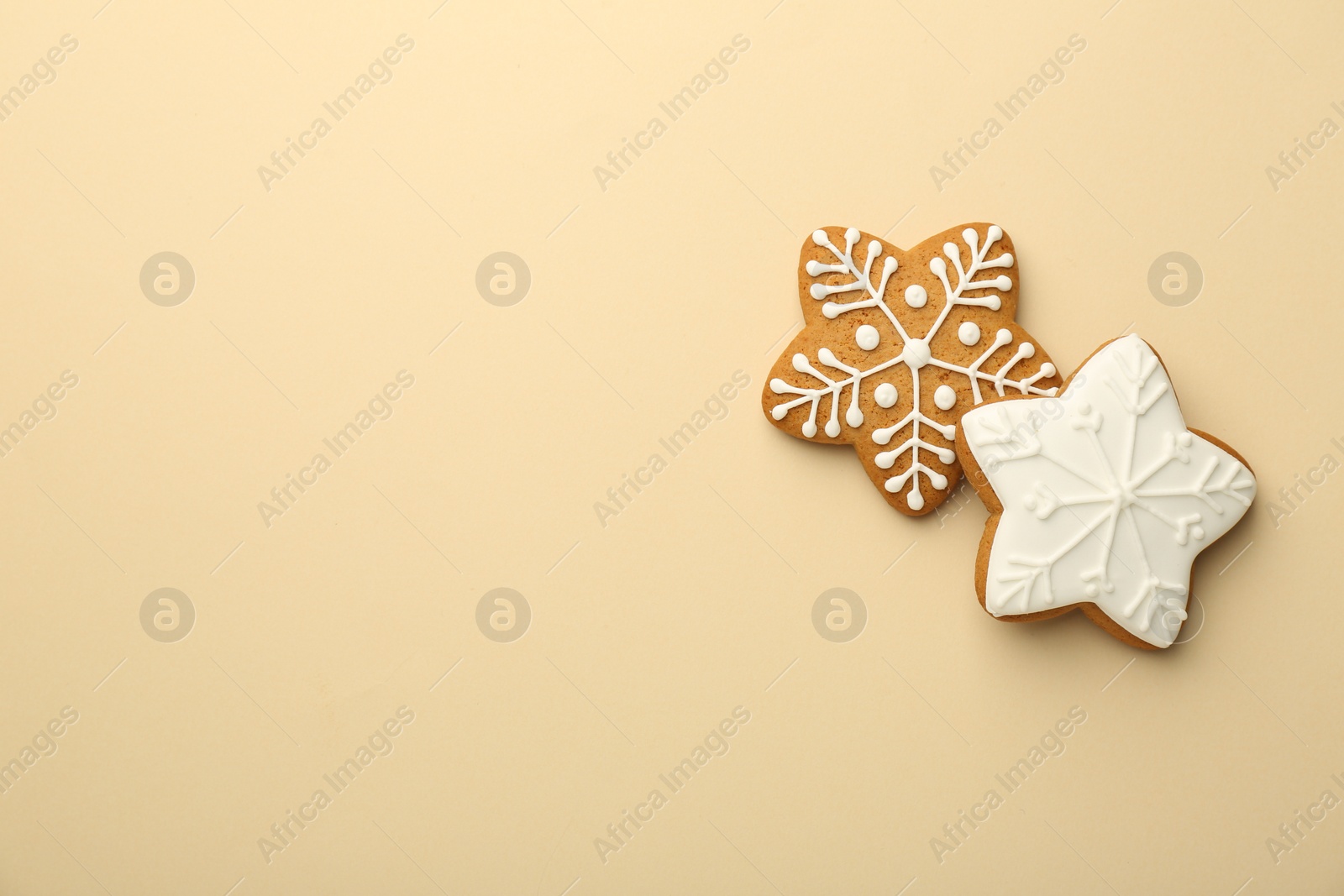 Photo of Tasty Christmas cookies with icing on beige background, flat lay. Space for text