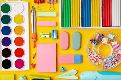 Photo of Many different school stationery on yellow background, flat lay. Back to school