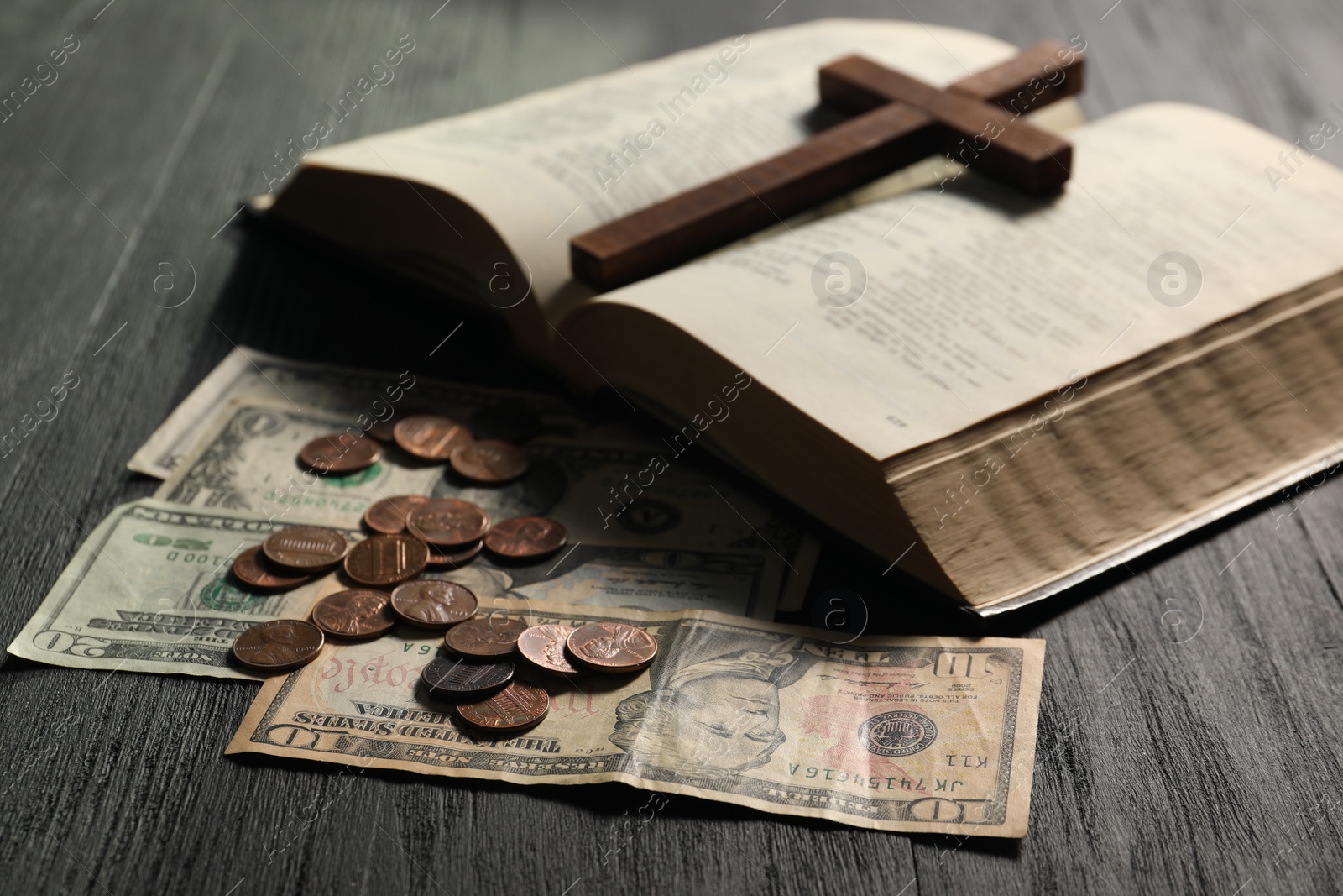 Photo of Donate and give concept. Coins, dollar banknotes, cross and Bible on wooden table, closeup